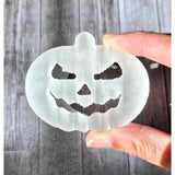 Selenite pumpkin carving by Moonlight Gemstones; translucent white jack-o'-lantern ornament.