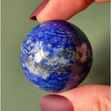 Lapis lazuli edelsteen bol 4-5 cm, diepblauw met witte en bruine insluitsels.