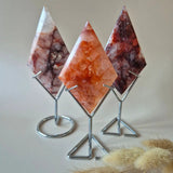 Three Fire Quartz diamond prisms on metal stands, pink-orange crystals with veining, Moonlight Gemstones.