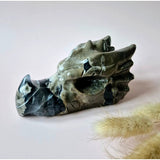 Volcano agate dragon skull sculpture, UV-reactive, 600 g with green-gray veining