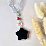 Moonlight Gemstones Edelsteen Kerst Ster Hangers: black star pendant with green and red beads on blue ribbon